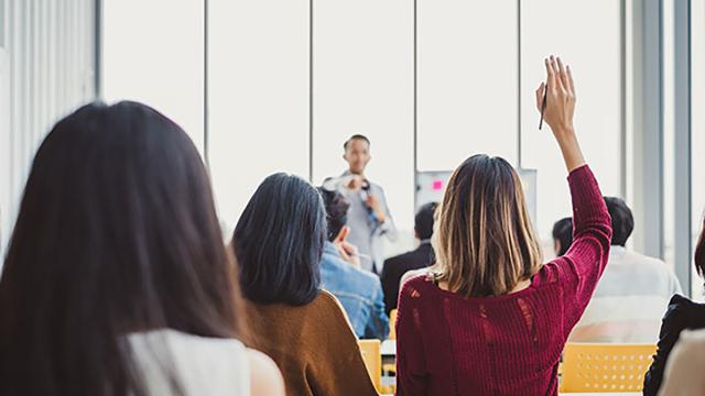 Person raising hand in classroom