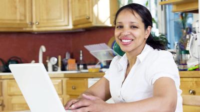 Adult seated at table in front of an open laptop