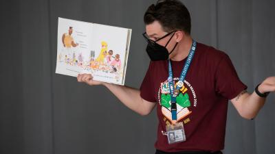 Staff member standing holding a book