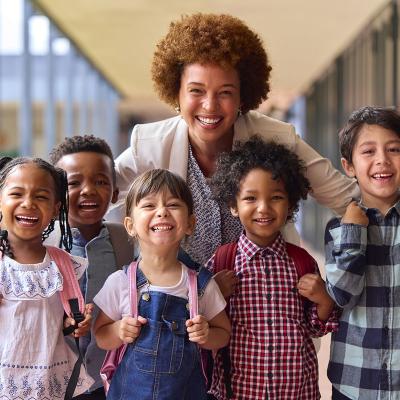 Five smiling kids in front of an adult