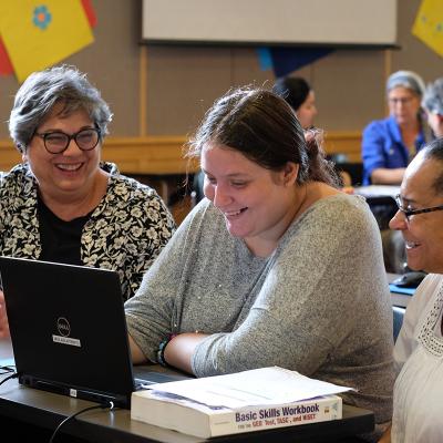 Three people working at a computer