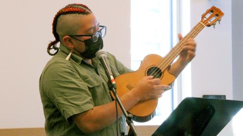 Photo of Fyre, aka Giggles, playing a ukulele.