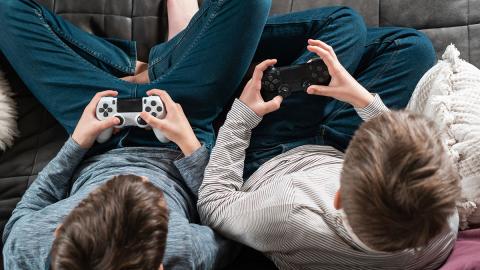 Photo of two children playing video games on controllers.