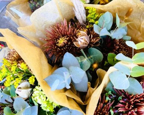 ariel close up photograph of three flower bouquets wrapped in paper