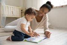 Image of a parent reading a book to their child in a nursery