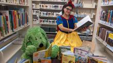 Photograph of stuffed bear wearing a summer reading t-shirt with a giant library card