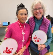 2 people holding fans