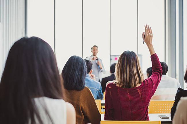 Person raising hand in classroom