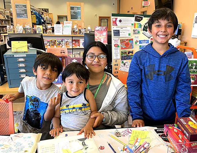 Four Summer Reading volunteers smiling at the camera