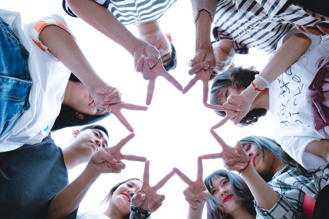 Teens in a circle looking from below