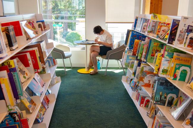 Inside Holgate Library, in a large room filled with bookshelves, and seating by the windows